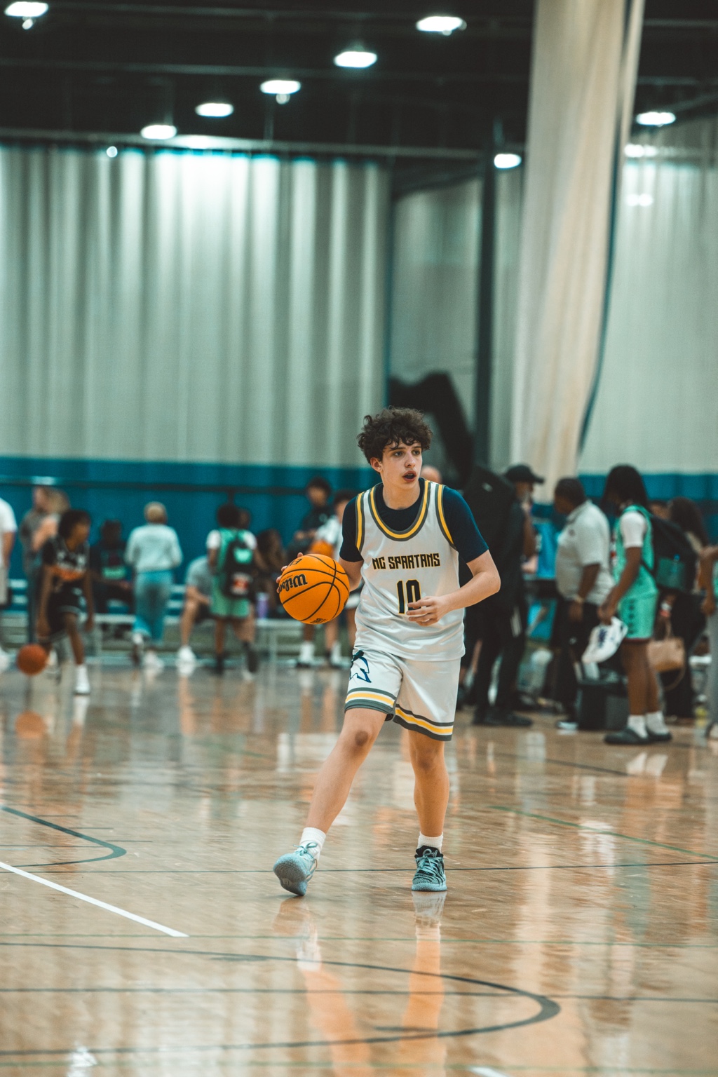 Noah dribbling the basketball in his number 10 NC Spartans uniform